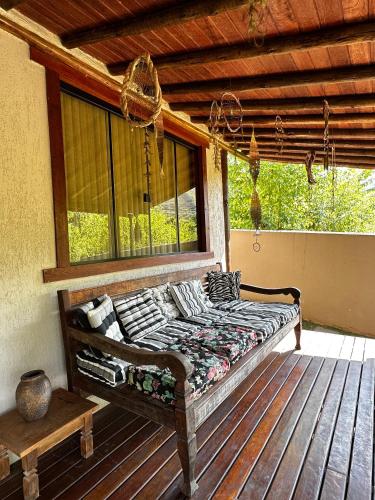 a bed on the porch of a house at Casa Barra do Sana in Sana