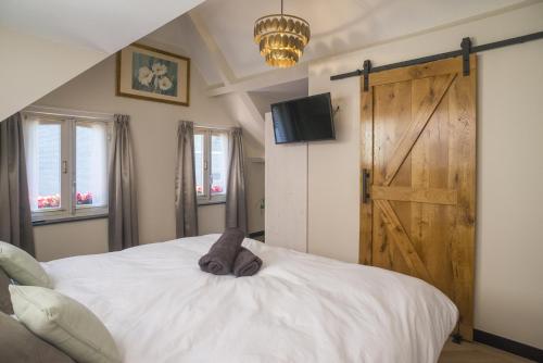 a bedroom with a large white bed and a wooden door at Harmony Room At The Best Location in Tilburg
