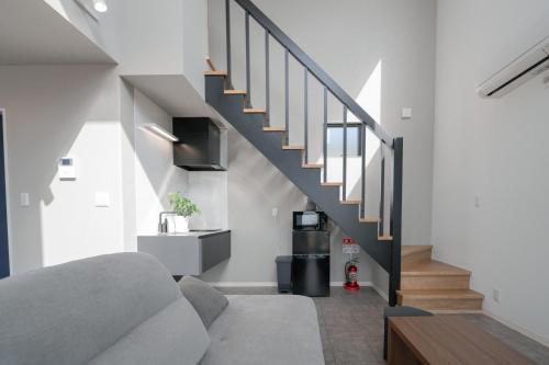 a living room with a staircase in a house at 新築オーシャンビュー離れ FLAG Awaji HANARE in Awaji
