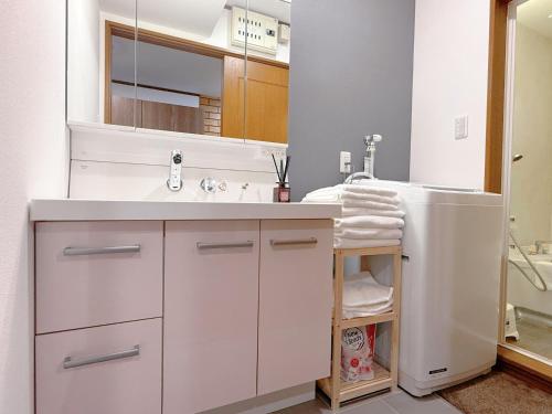 a white bathroom with a sink and a mirror at NewDayHouse日式洋房独栋最多住10人 新今宫站近温泉通天阁天王寺 机场直达 半小时到世博会 in Osaka
