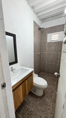 a bathroom with a toilet and a sink and a mirror at Cabañas en Cartagena JhonliMar in Isla de Tierra Bomba