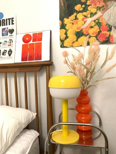 a yellow and orange lamp in a bedroom with a vase at STAY MOMENT #Suwon in Suwon