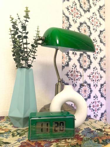 a table with a lamp and a clock and a vase at STAY MOMENT #Suwon in Suwon