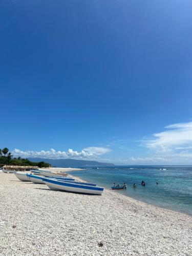 a group of boats on a beach with people in the water at Hotel Al Mare in Santa Cruz de Barahona