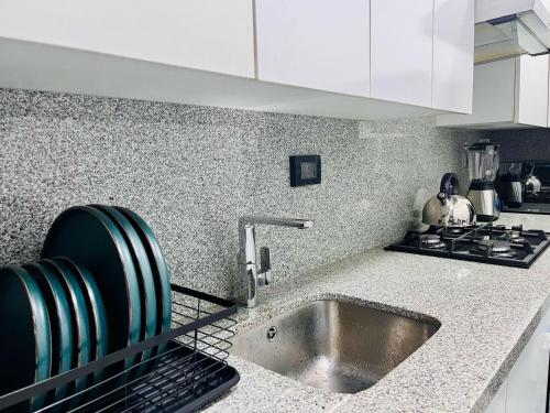 a kitchen counter with a sink and a stove at Hermoso departamento en el Centro de Lima in Lima