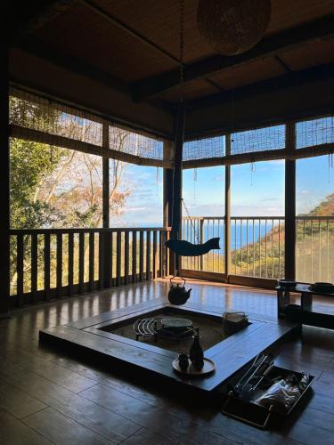 a living room with a view of a living room with a fireplace at 熱海 海炉 天然温泉 花火見える 海を望む絶景ヴィラ in Atami