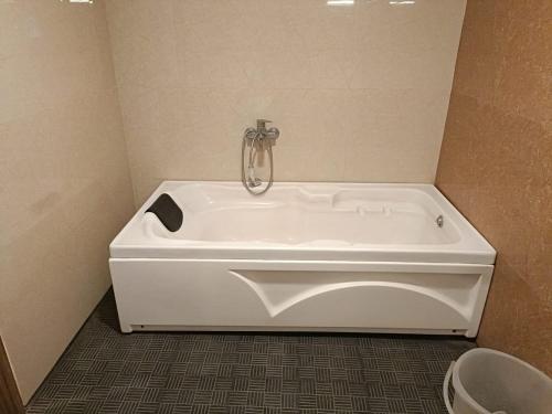 a white bath tub in a bathroom with at Rani and Rani Hotel rooms in Puducherry