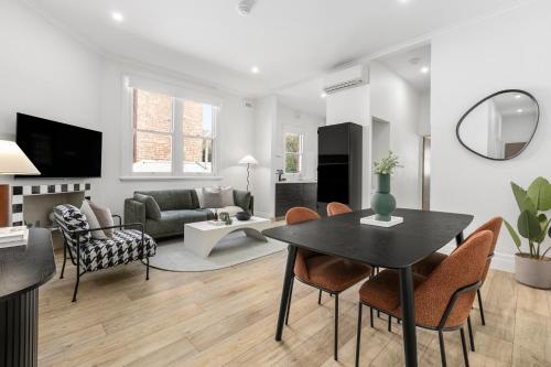 a living room with a table and chairs at Simpson Street Apartments by Urban Rest in Melbourne