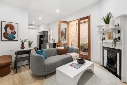 a living room with a couch and a fireplace at Simpson Street Apartments by Urban Rest in Melbourne
