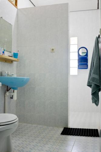 a bathroom with a blue sink and a toilet at Sendowan Baru Amurang in Amurang