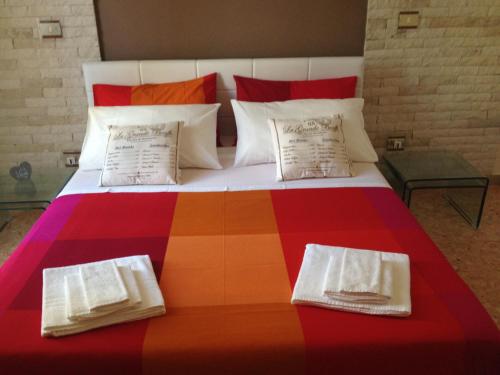 1 cama grande y colorida con 2 almohadas en Don Mico 'Case Vacanze', en Riposto