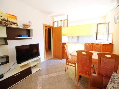 a kitchen and dining room with a table and a television at Apartment in Dinji ka by the Beach in Dinjiška