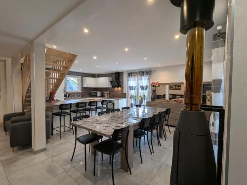 une salle à manger et une cuisine avec une grande table et des chaises dans l'établissement Évasion Vosgienne: Chalet de Luxe, Spa, Sauna, Proche Randos et Stations de Ski - FR-1-589-313, à Fresse-sur-Moselle