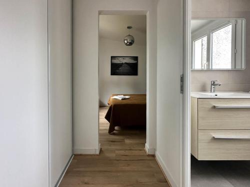 un couloir menant à une salle de bain avec un lavabo dans l'établissement Villa rénovée à La Palmyre pour 6 pers. - Patio, wifi, proche plage et commerces - FR-1-705-85, aux Mathes