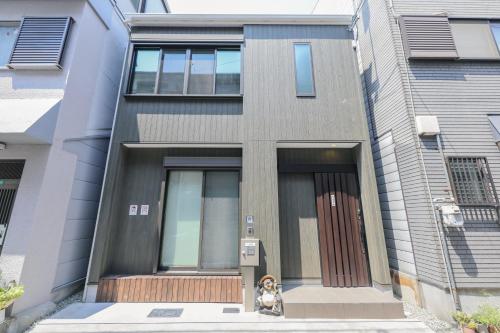 a dog sitting in front of a building at 大阪指定特区民泊小田別荘なんば店OdaVillaNamba in Osaka