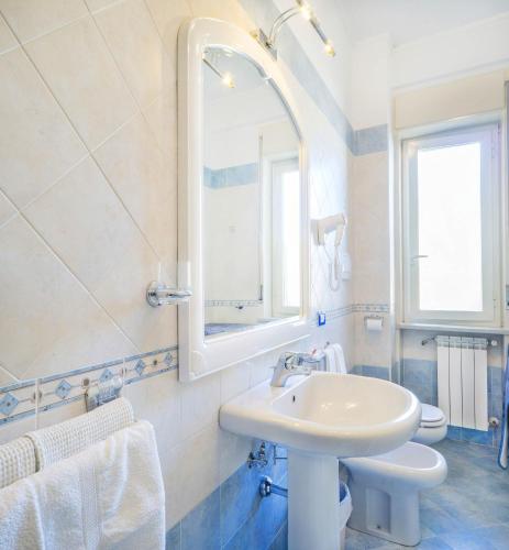 a white bathroom with a sink and a mirror at B&B La casa D'amare in Maiori