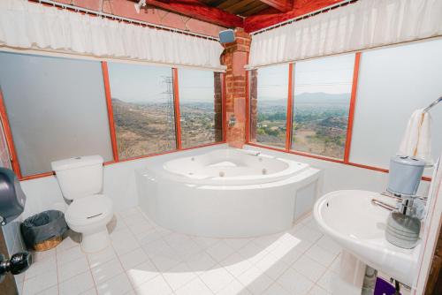 a bathroom with a tub and a toilet and a sink at Hotel Casa Cantera in El Carmen
