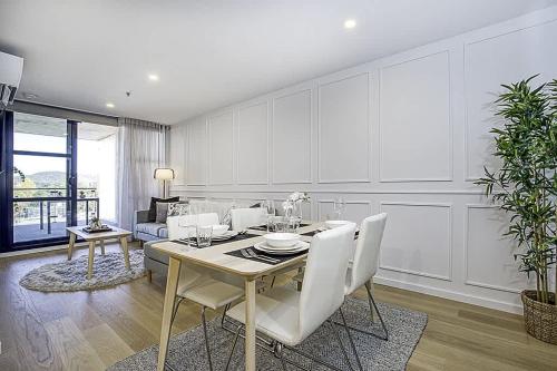 a white dining room with a table and chairs at 2 Bedroom Luxury & style in the heart of Braddon in Braddon