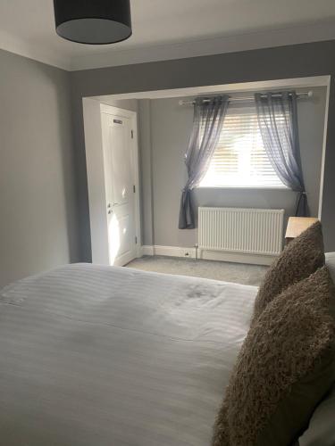 a bedroom with a large white bed and a window at Autumn House in Cambridge