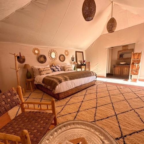 a bedroom with a large bed in a room at Nada luxury desert camp in Merzouga