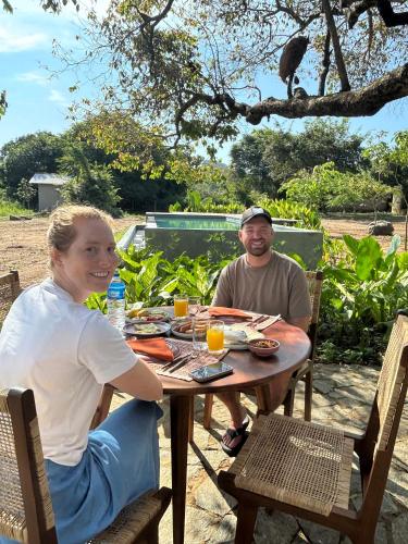 a man and a woman sitting at a table with a meal at Tranquil Trails Sigiriya in Dambulla