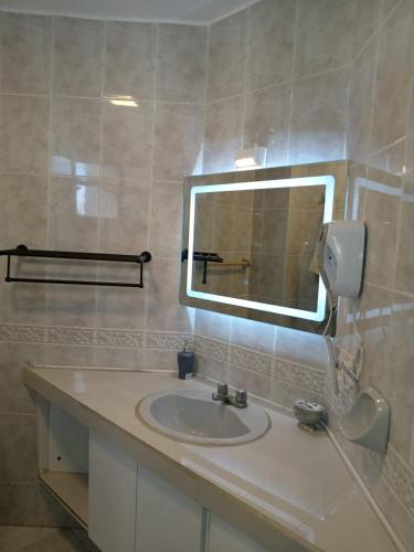 a bathroom with a sink and a mirror at Departamento 4 habitaciones 12 personas vista al mar 8vo piso Playa Almendro in Tonsupa