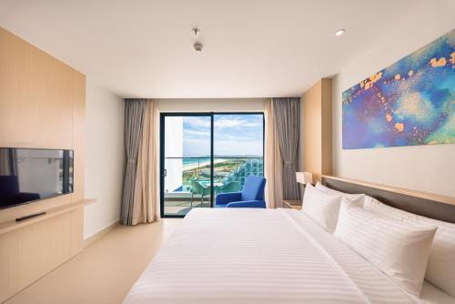a hotel room with a bed and a tv at The Empyrean Cam Ranh Beach Resort in Cam Ranh