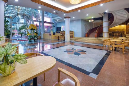 a lobby with tables and chairs in a building at Nha Trang Lodge Hotel in Nha Trang