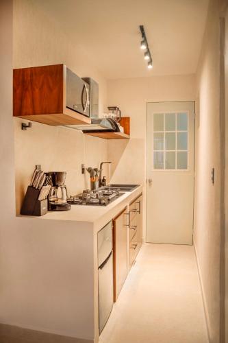 a kitchen with a stove top oven next to a door at Bonito Departamento en Tulum in Tulum