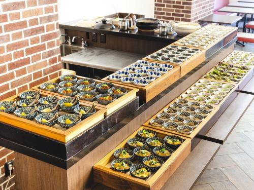 a row of trays filled with different types of food at KOKO HOTEL Akabane Station - formerly Hotel Wing International Tokyo Akabane in Tokyo