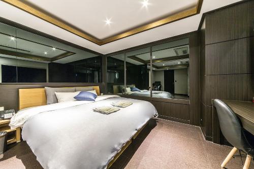 a bedroom with a large bed and a desk and a bed sidx sidx sidx sidx at Incheon Seven Hotel in Incheon