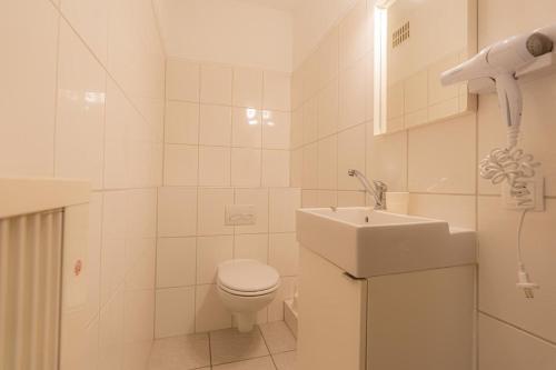 a white bathroom with a toilet and a sink at Wohnung-D-306 in Böhl