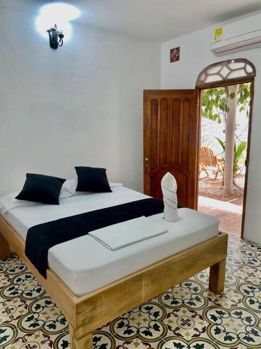 a bedroom with a large bed with a wooden frame at Hotel Boutique Casa Marco in Ciénaga de Oro