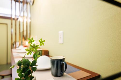 a table with a vase and a plant on it at 鶴橋和モダン古民家 縁家 Enya-Japanese Townhouse 2min to Tsuruhashi Station Easy Access to Namba and Dotonbori in Osaka