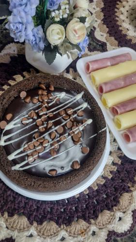 a chocolate cake with nuts on a table with other desserts at Hostel Canto da Alegria in Itanhaém