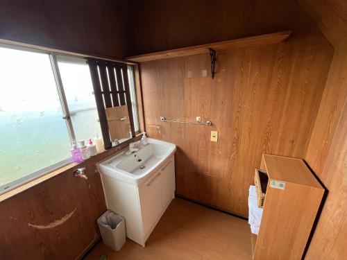 a bathroom with a white sink and a window at ぶどう畑に囲まれた貸切宿 バーベキュー可能 白百合醸造から徒歩すぐ"Vineyard Vista" Vacation rental BBQ permitted short walk from Winery in Yamanashi