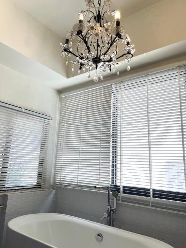 a bathroom with a chandelier and a bath tub at Hour Roots in Tainan