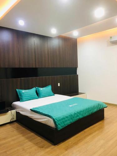 a bedroom with a large bed with blue pillows at PUPON Homestay and Coffee in Quang Ngai