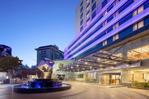 a building with a fountain in the middle of a street at Sunworld Hotel Wangfujing in Beijing