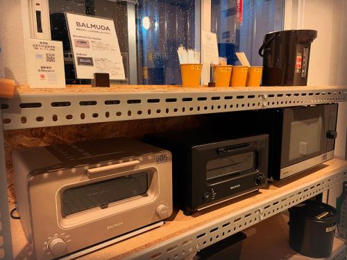 a microwave and a toaster oven on a shelf at ＳＡＫＡＴＡＮＴＯ Ｃｏｎｔａｉｎｅｒ Ｈｏｔｅｌ ＣＡＭＰＳ - Vacation STAY 31777v in Sakata