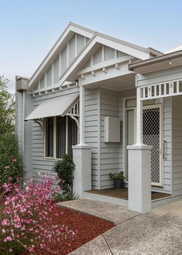 a house with a front porch with flowers at Fermoy Cottage in Healesville