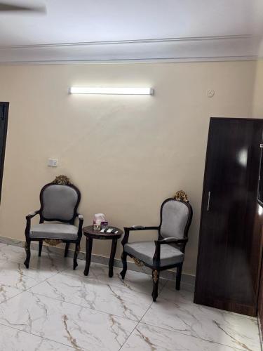 two chairs and a table in a room at A One Boutique Hotel Dha in Karachi