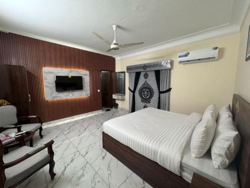 a bedroom with a bed and a desk and a tv at A One Boutique Hotel Dha in Karachi
