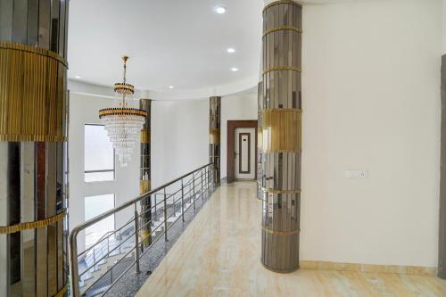 a hallway with wooden columns and a chandelier at Hotel O The Grand Farm in Jaipur