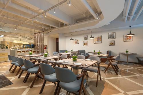 a restaurant with tables and chairs in a room at Sunworld Hotel Wangfujing in Beijing
