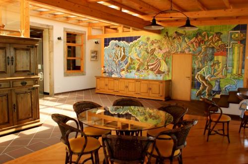 Solar do Alambique في Angeja: غرفة طعام مع طاولة وجدارية كبيرة