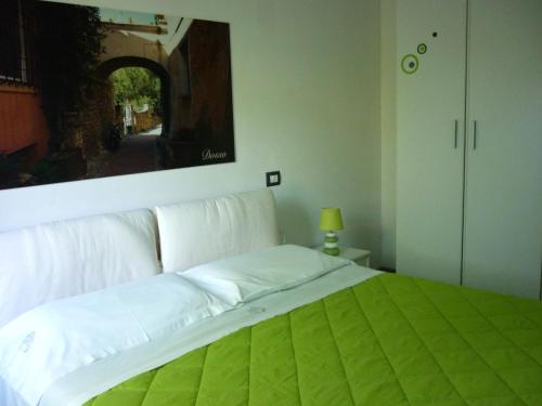 a bedroom with a white bed with a painting on the wall at Costa Morroni in Levanto