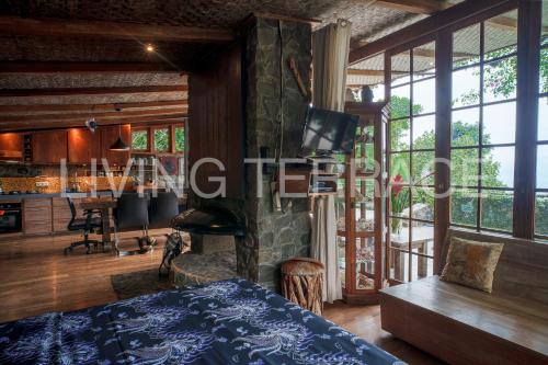 a bedroom with a bed and a living room with a fireplace at Rumah Lereng Bandung in Bandung