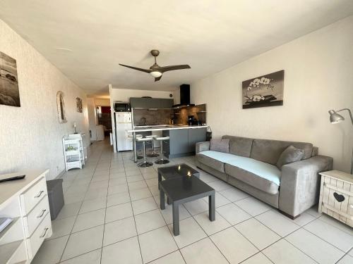 un salon avec un canapé et une cuisine dans l'établissement Location saisonnière à Valras-Plage pour 2 personnes - FR-1-781-95, à Valras-Plage