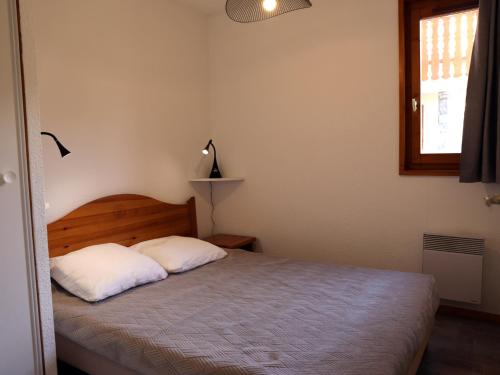 une chambre avec un lit avec deux oreillers blancs dans l'établissement Appartement confortable 6 pers, quartier calme - FR-1-508B-1, à Aussois